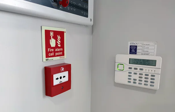Fire alarm call point and alarm keypad on a wall
