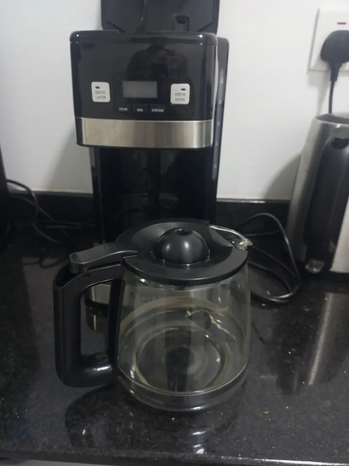 Programmable drip coffee maker with glass jug back on the counter after repair