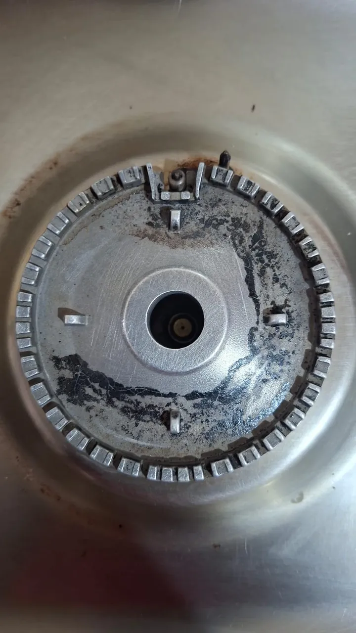 Gas cooker burner base cleaned during a repair