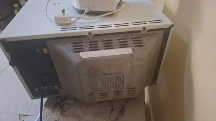 Back of a microwave before cleaning and repair