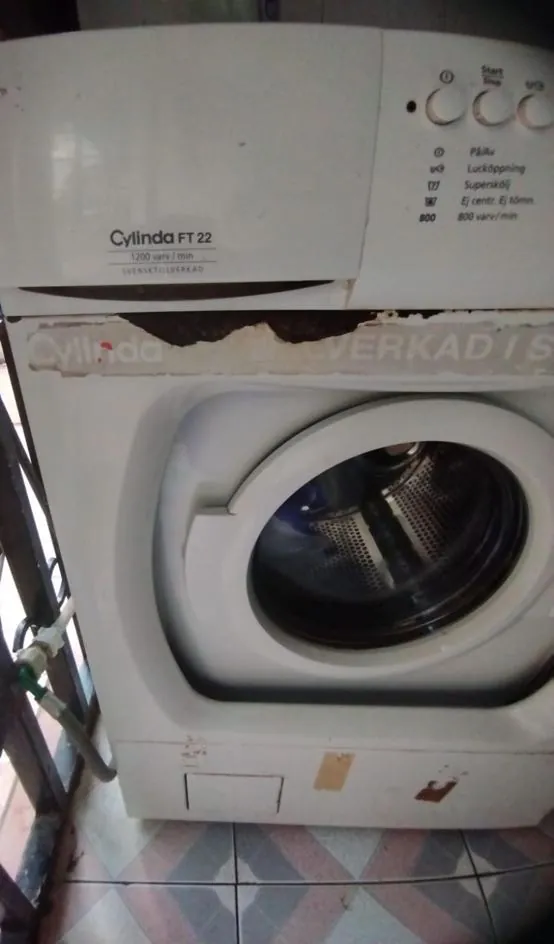 Older front-load washing machine on a repair visit