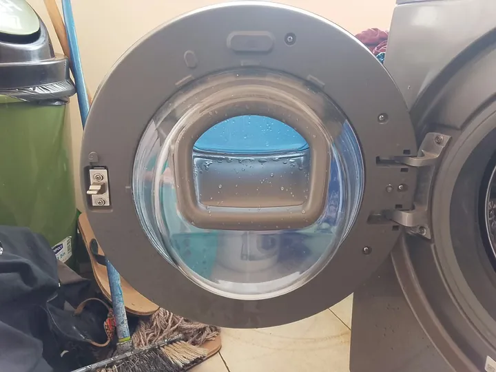 Front-load washer door open showing the glass and seal