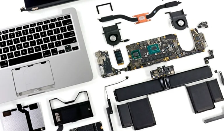 Laptop taken apart with the keyboard, logic board, fans and battery laid out