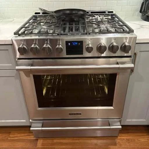 Stainless six-burner range cooker in a home kitchen